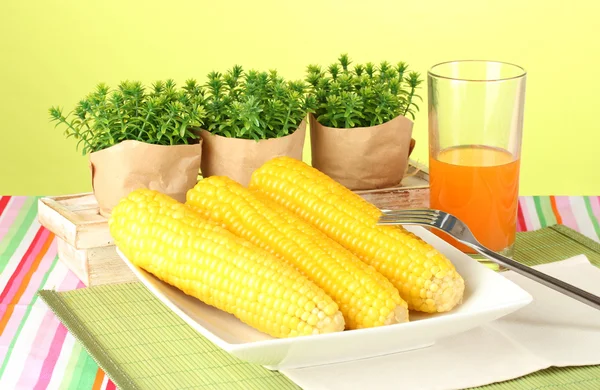 Gekochter Mais und Saft auf grünem Hintergrund — Stockfoto