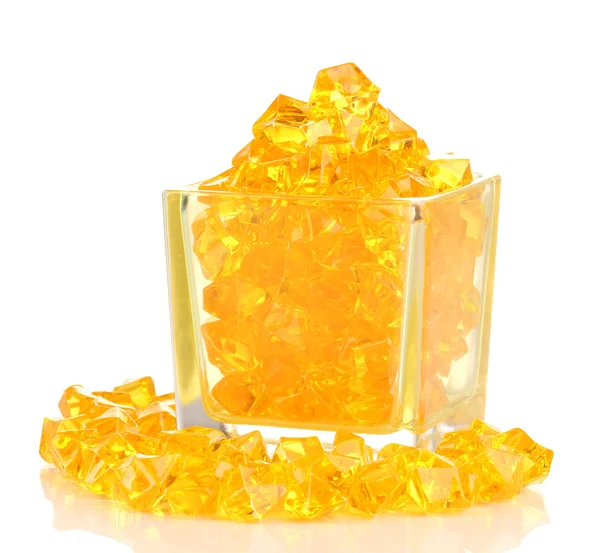 A glass with yellow decorative stones isolated on white — Stock Photo, Image