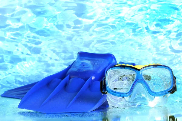 Blauwe flippers en masker op blauwe zee achtergrond — Stockfoto