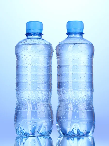 Plastic flessen water op blauwe achtergrond — Stockfoto