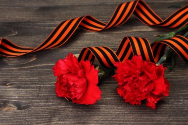 Carnations and St. George's ribbon on grey wooden background clipart