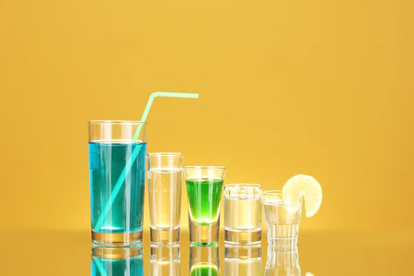 Μια ποικιλία από αλκοολούχα ποτά σε κίτρινο φόντο — Φωτογραφία Αρχείου