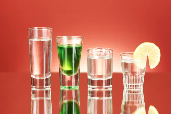 Eine Vielzahl alkoholischer Getränke auf rotem Hintergrund — Stockfoto