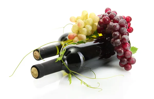 Botellas de vino y uvas maduras aisladas sobre blanco — Foto de Stock