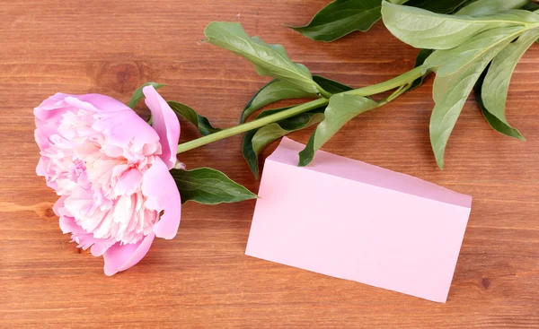 Różowa piwonia z karty na drewniane tła — Zdjęcie stockowe
