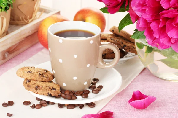 Filiżankę kawy, ciasteczka, jabłka i kwiaty na stole w kawiarni — Zdjęcie stockowe