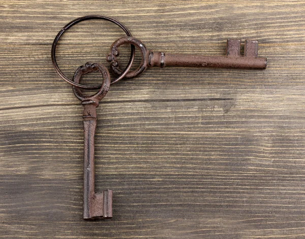 A bunch of antique keys on wooden background — Stock Photo, Image