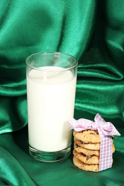Glass of milk and cookies on green cloth background — Stock Photo, Image