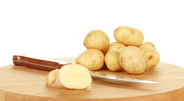 Jonge aardappelen op een snijplank met mes op witte achtergrond close-up — Stockfoto