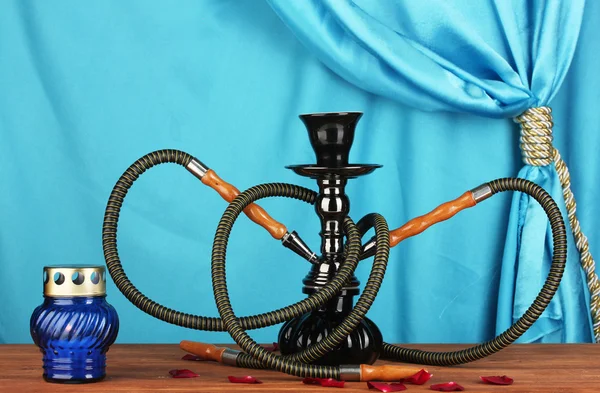 Hookah on a wooden table on a background of blue curtain close-up — Stock Photo, Image