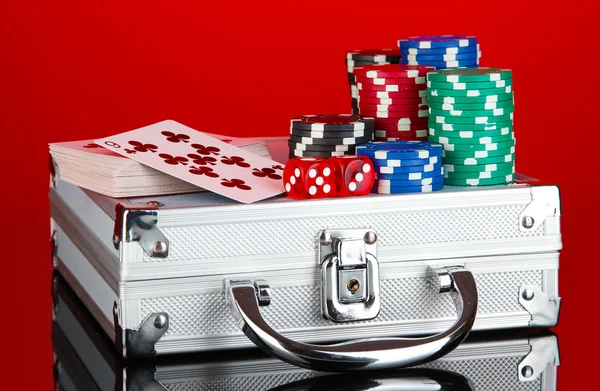 Poker set on a metallic case on bright red background — Stock Photo, Image