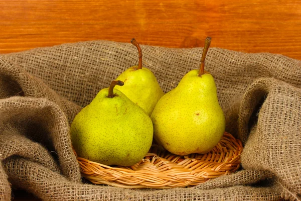 早熟梨在麻袋上木制背景特写 — 图库照片