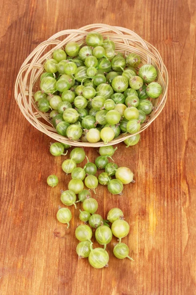 Green gooseberry in basket on wooden background — Stock Photo, Image