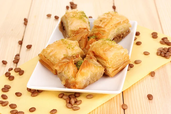 Sweet baklava on plate on wooden background — Stock Photo, Image