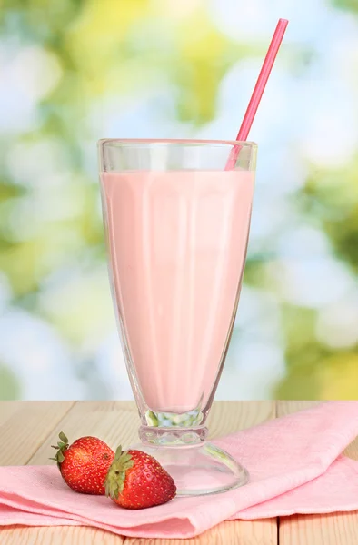 Strawberry milk shake on wooden table on bright background — Stock Photo, Image