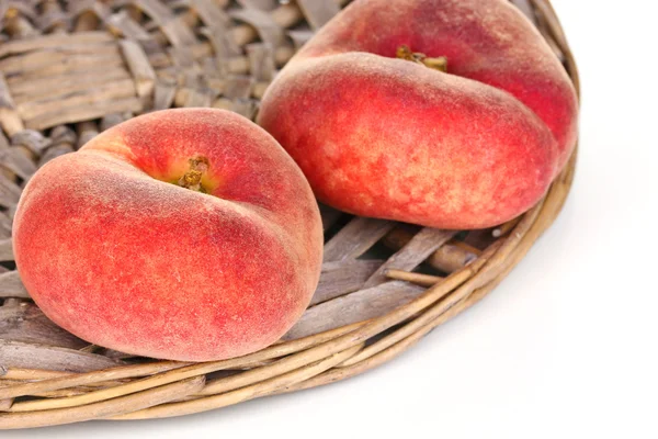 Ripe fig peaches on wicker mat isolated on white — Stock Photo, Image
