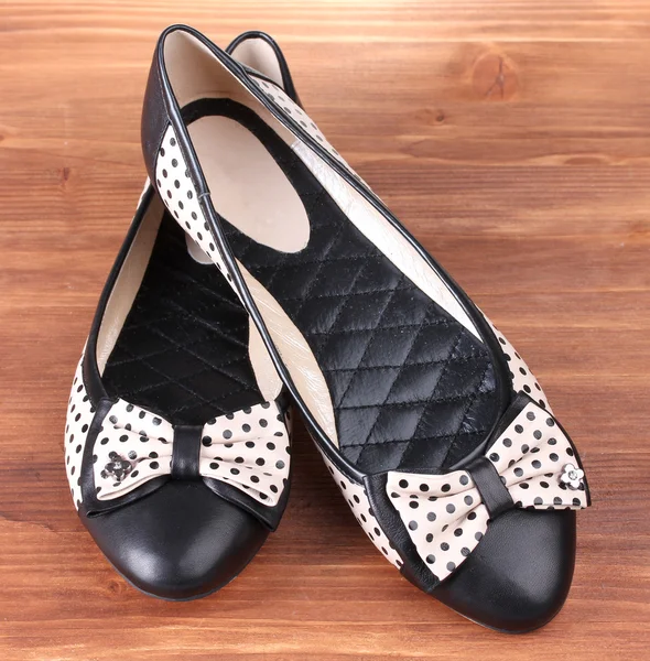 Female flat ballet shoes patterned with black polka dots on wooden background — Stock Photo, Image