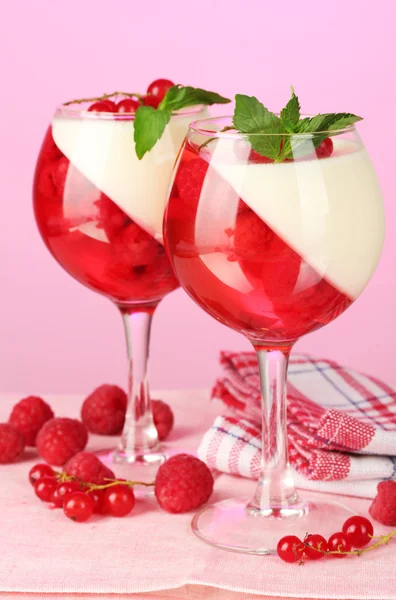 Gyümölcs kisselek bogyókkal szemüveg rózsaszín háttér — Stock Fotó
