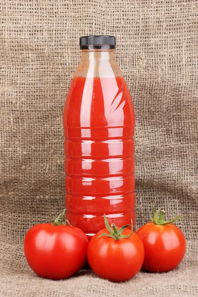 麻布背景上瓶中的番茄汁 — 图库照片
