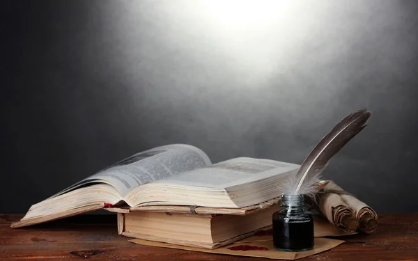 老书、 卷轴、 羽毛笔和灰色的背景上的木桌子上的墨水瓶 — 图库照片