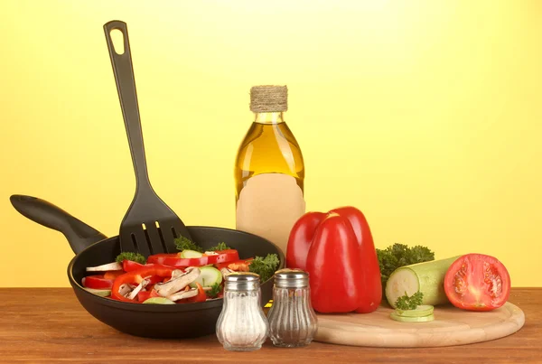 Сковородка с овощами на желтом фоне — стоковое фото