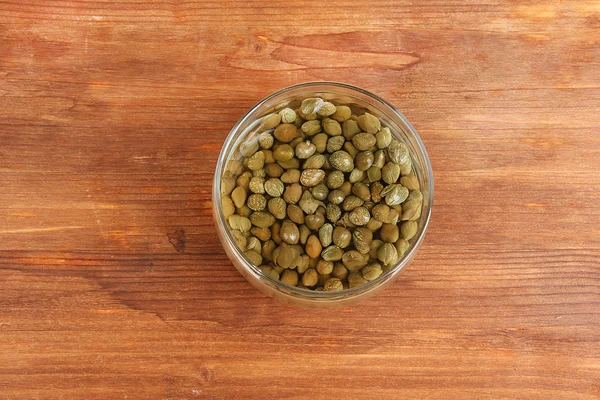 Jar with capers on wooden background — Stock Photo, Image