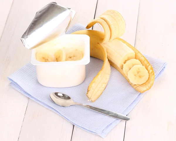 Yogurt con plátano sobre fondo de madera — Foto de Stock