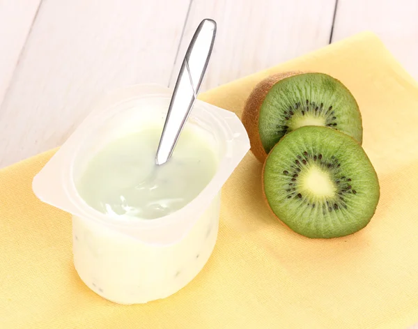Yoghurt med kiwi på servett på trä bakgrund — Stockfoto