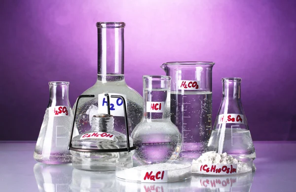 Tubos de ensaio com vários ácidos e produtos químicos sobre fundo brilhante — Fotografia de Stock