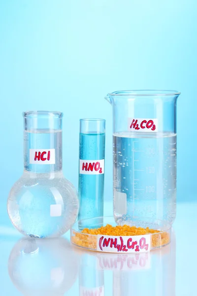 Provrör med olika syror och kemikalier på blå bakgrund — Stockfoto