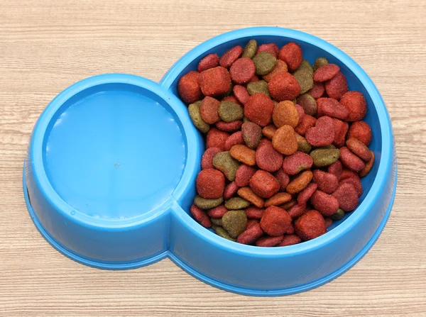 Kuru Köpek Gıda ve ahşap zemin üzerinde mavi kapta su — Stok fotoğraf