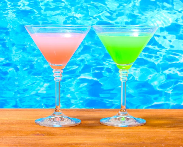 Brýle koktejlů na dřevěný stůl na pozadí modré moře — Stock fotografie