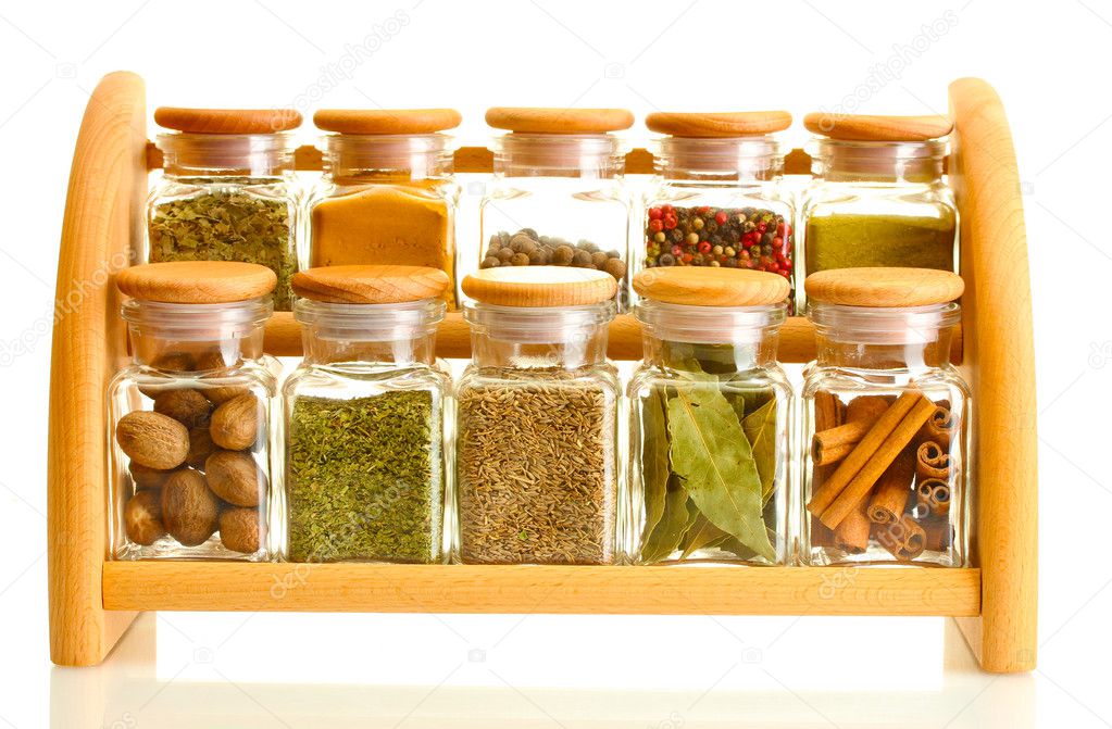 Powder spices in glass jars on wooden shelf isolated on white