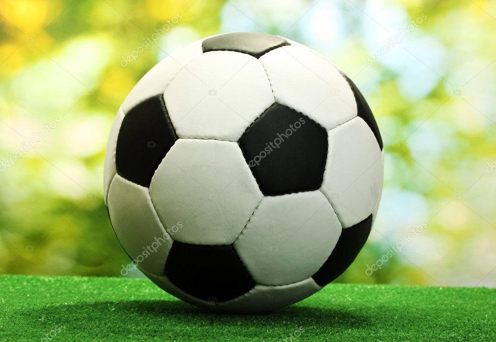 Football ball on artificial green grass