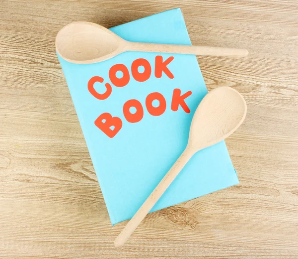 Kookboek en keukengerei op houten achtergrond — Stockfoto