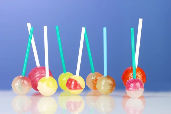 Lollipops brillantes y deliciosos sobre fondo azul oscuro de cerca — Foto de Stock