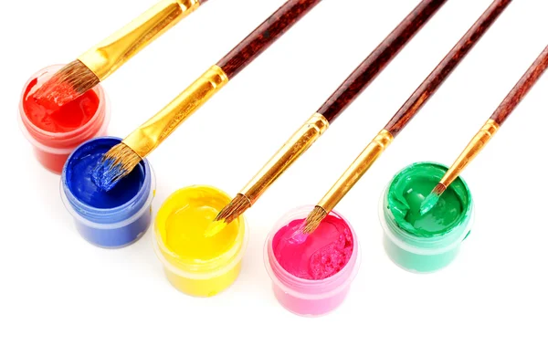 Brushes on the jars with colorful gouache on white background close-up — Stockfoto
