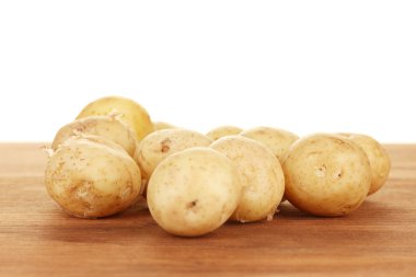 beyaz zemin üzerinde bir masada genç patates