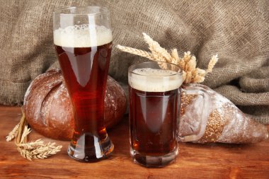 Two glasses of kvass with bread on canvas background close-up clipart
