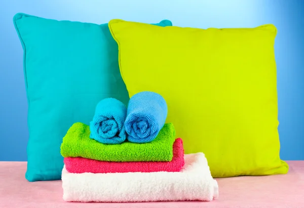Pillows and towels on blue background — Stock Photo, Image