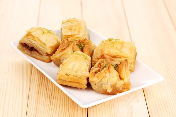 Baklava dulce en plato sobre fondo de madera — Foto de Stock