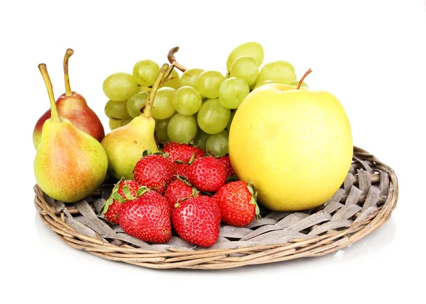Спелые сладкие фрукты и ягоды на плетеном коврике изолированы на белом — стоковое фото