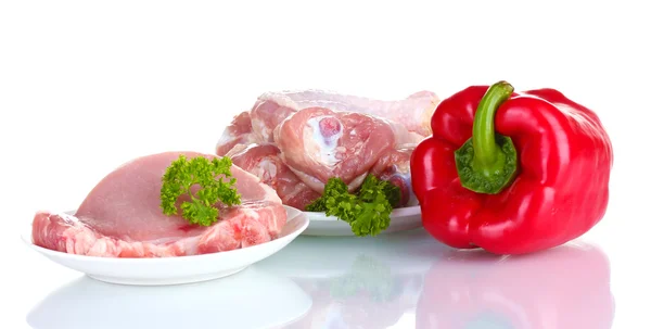 Fresh pepper with raw chicken drumsticks and pork steak on cutting board isolated on white — Stock Photo, Image