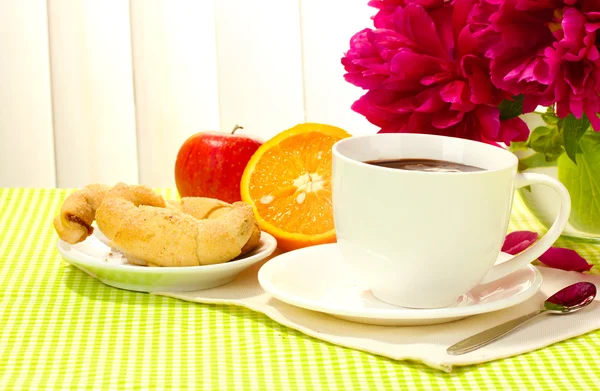 Xícara de chocolate quente, maçã, laranja, biscoitos e flores na mesa no café — Fotografia de Stock