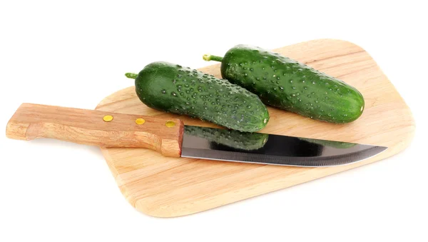 Verse komkommers en mes op houten plank geïsoleerd op wit — Stockfoto