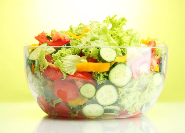 在绿色背景上的透明碗新鲜蔬菜沙拉 — 图库照片
