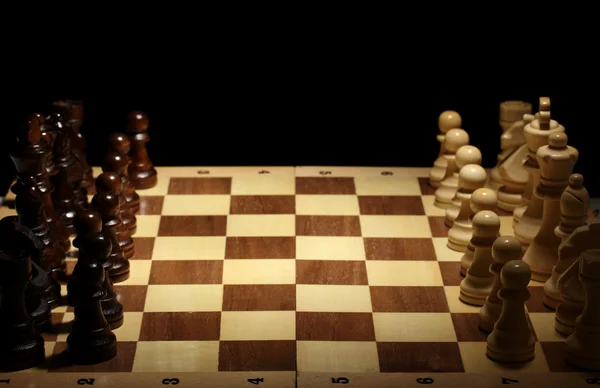 Tablero de ajedrez con piezas de ajedrez aisladas en negro — Foto de Stock