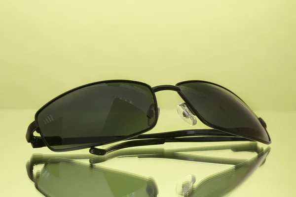 Солнечные очки на зеленом фоне — стоковое фото