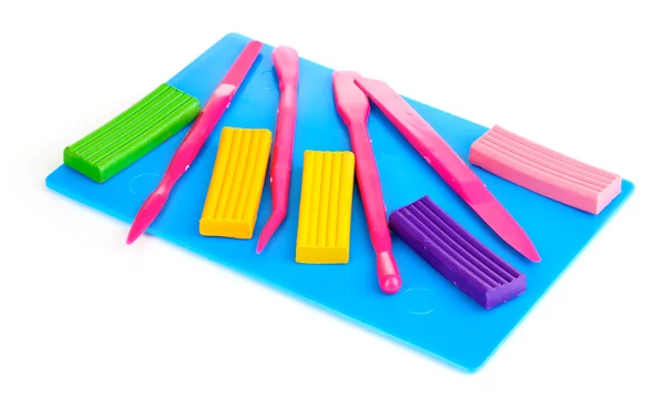 stock image Children bright plasticine on desk with stacks isolated on white