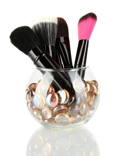Cepillos de maquillaje en un tazón con piedras aisladas en blanco — Foto de Stock